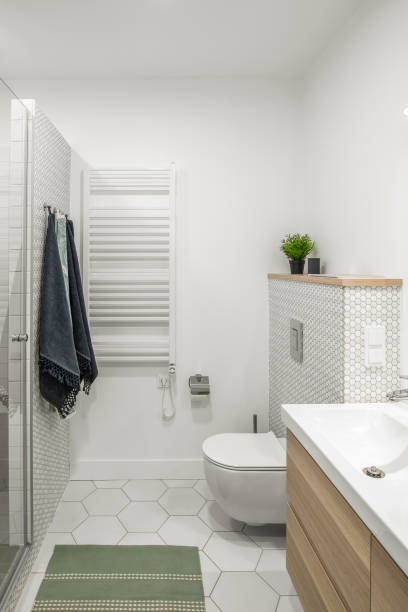 istock Modern minimalist bathroom interior design with white tiles, two white sinks and natural wood furniture 1333433667