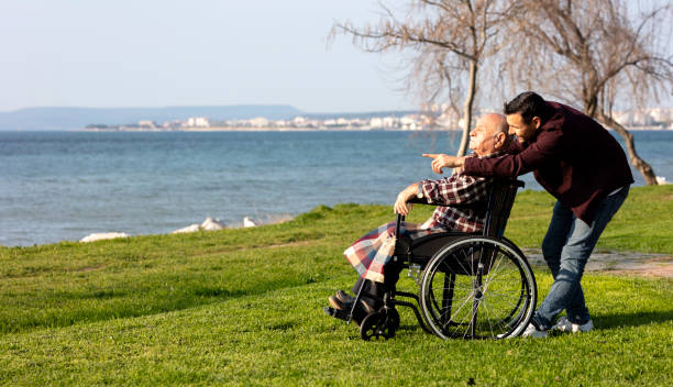 istock Elderly man in wheelchair with young man 1333435320