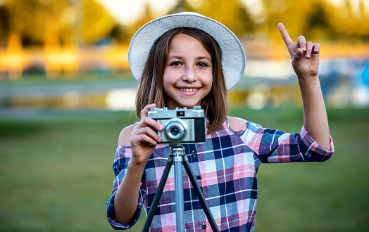 Young photographer. Little girl making a photo with vintage photo camera