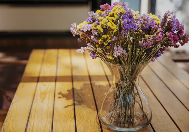 vase en verre avec de belles fleurs séchées lumineuses sur une table en bois dans un café de rue - flower pot vase purple decor photos et images de collection