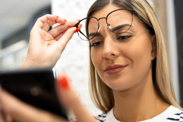 istock Girl with eyesight problems trying to read phone 1333437275