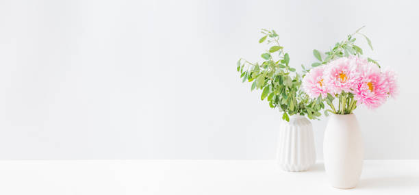 istock Pink flowers in a vase on a light background at home interior. Modern interior design 1333437401