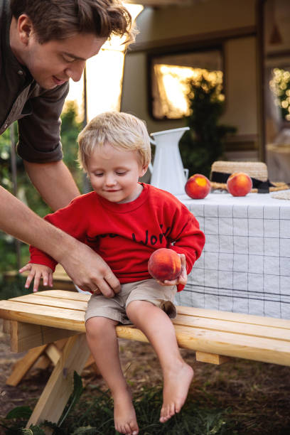 young dad spending time with child. male parent caring of little kid boy sitting outside camper van - child little boys male caucasian imagens e fotografias de stock