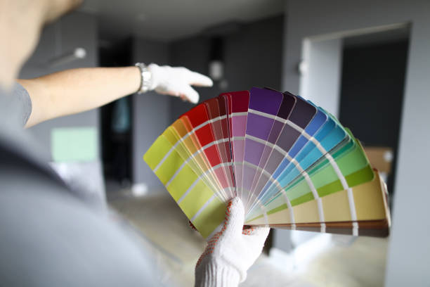 repairman looking at walls and palette and trying to choose color for interior - home decorator house painter color swatch paint imagens e fotografias de stock