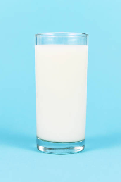 istock Glass of milk on blue background 1333444477