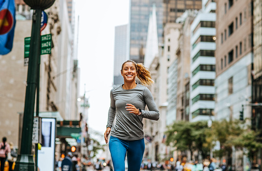 A young Caucasian woman jogging on New York City streets