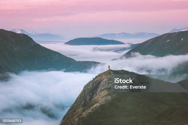 Traveler Hiking Above Mountain Clouds Enjoying Norway Sunset Landscape Travel Adventure Lifestyle Vacation Outdoor Epic Trip Stock Photo - Download Image Now