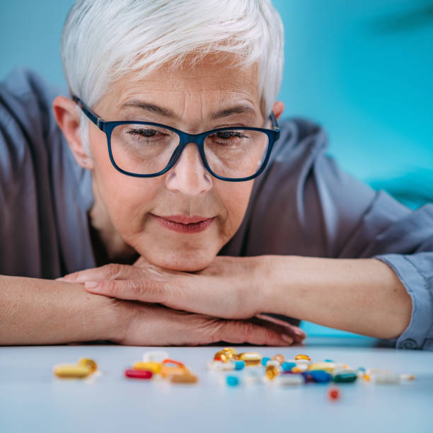istock Prescribed medication non-adherence. Senior female patient counting pills. 1333455892