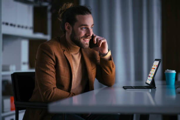 istock Handsome Businessman Having a Phone Call In his Office While Looking Up Something on his Tablet 1333458141