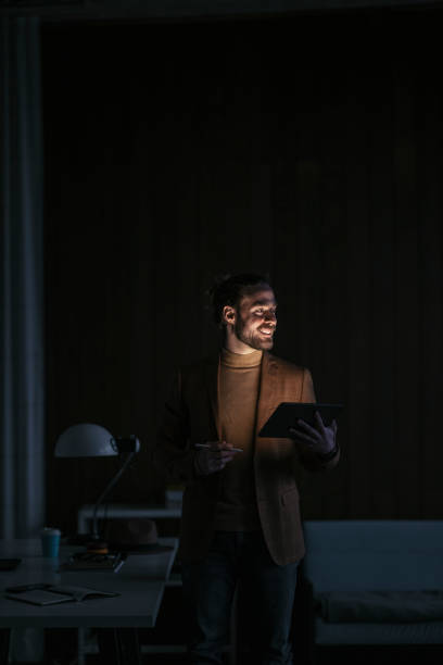 istock Handsome Businessman Working Overtime, Standing in his Office Using the Tablet 1333458153