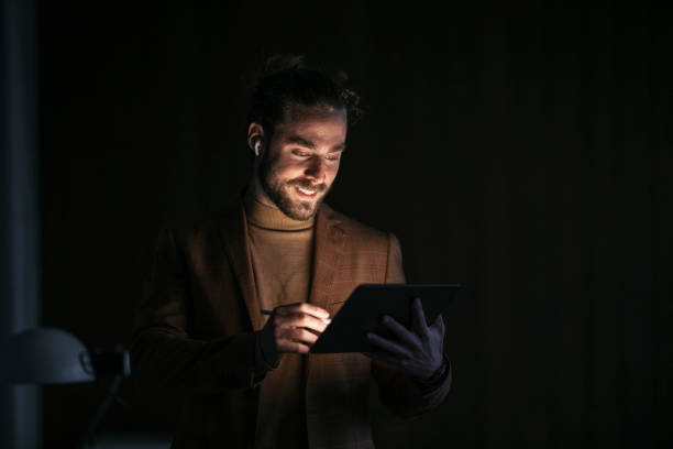 istock Handsome Businessman Working Overtime, Standing in his Office Using the Tablet 1333458155