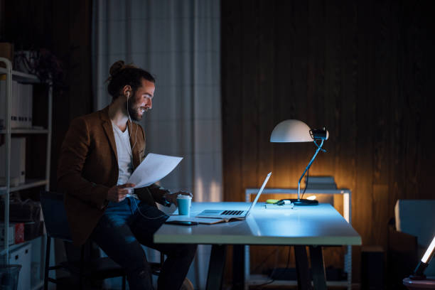 istock Handsome Businessman Smiling Holding a Coffee Cup and Papers Negotiating Something While Having a Video Call over his Laptop 1333458186