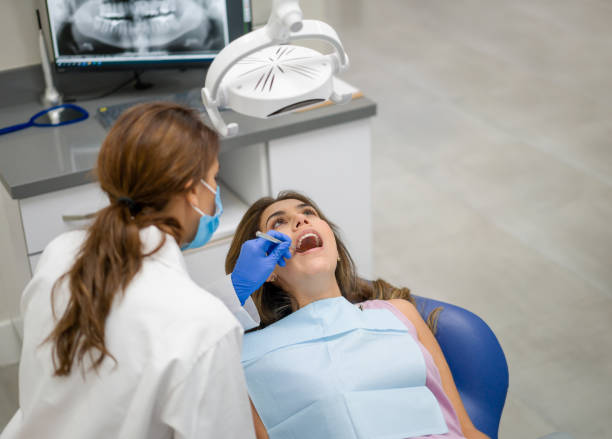 istock Woman at the dentist getting her teeth cleaned 1333458386