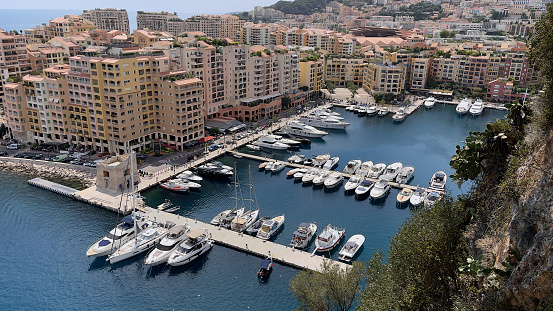 Monte Carlo,Monaco- August 3,2021: A beautiful panoramic view of bay in Monte Carlo in Monaco part of the famous French riviera lined with super luxury yachts, boats and beautiful colorful houses dotting the hill over looking Mediterranean sea with deep blue water