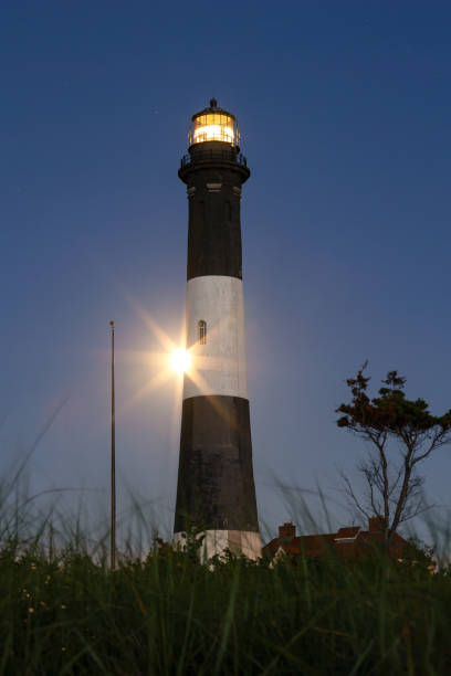 istock Full moon rising behind a tall stone lighthouse 1333465731