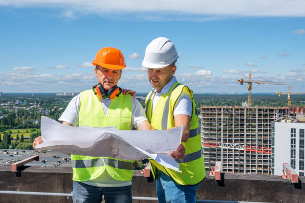 istock Men in a white helmet hold a construction plan and inspect the construction site 1333467398