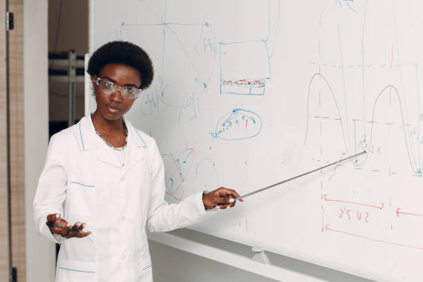istock African American woman math teacher stands at blackboard with pointer 1333469655