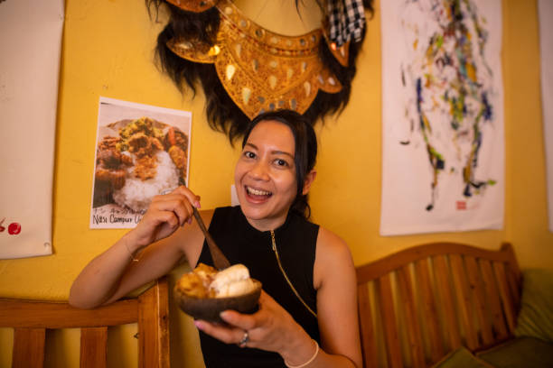 インドネシアのレストランでデザートを食べる幸せなアジアの女性 - women eating ice cream indigenous culture ストックフォトと画像