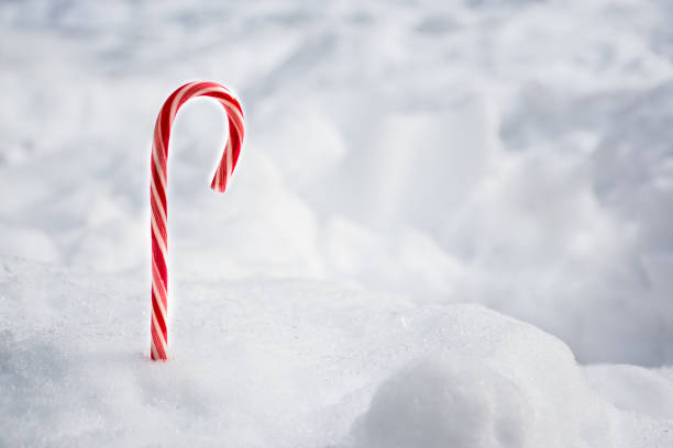istock Christmas candy peppermint cane with snowfall background. Space for text 1333477542
