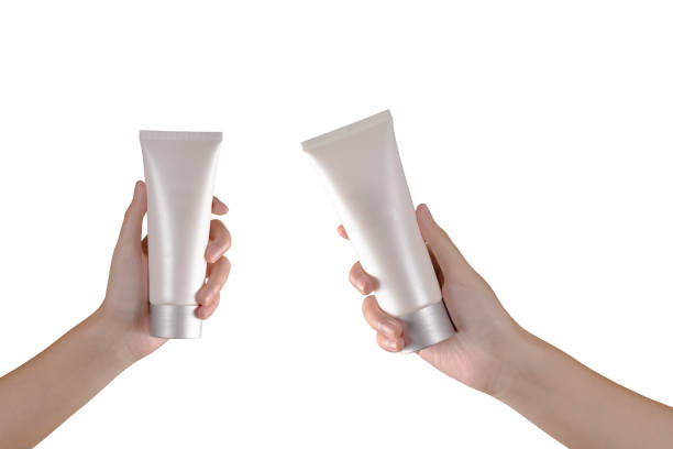young female hands holding blank white squeeze bottle plastic tube on white background. - moisturizer cosmetics merchandise human hand imagens e fotografias de stock