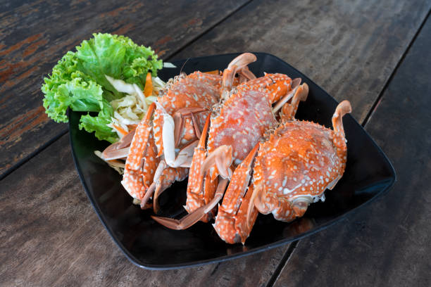 istock steamed blue swimming crabs on black dish on wooden table 1333479308