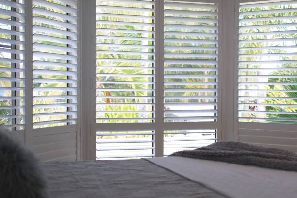 Plantation shutters - selective focus Luxury white plantation shutters in bedroom shutter stock pictures, royalty-free photos & images