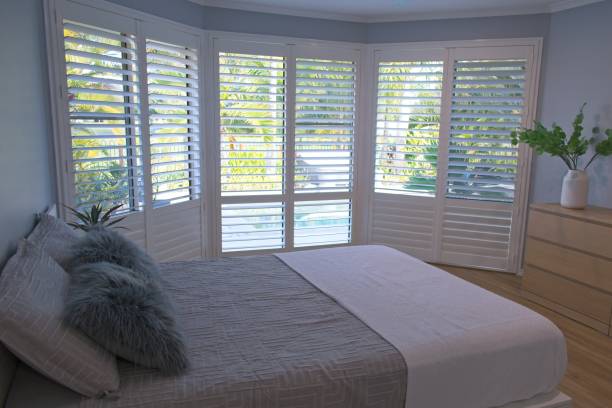 Plantation shutters Luxury plantation shutters in bedroom shutter stock pictures, royalty-free photos & images