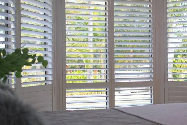 Luxury white plantation shutters in bedroom