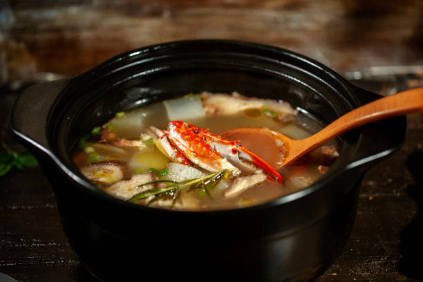 crab soup in cooking pot on table