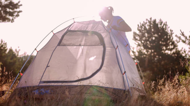 istock Building a tent at sunset while camping in nature. 1333495551