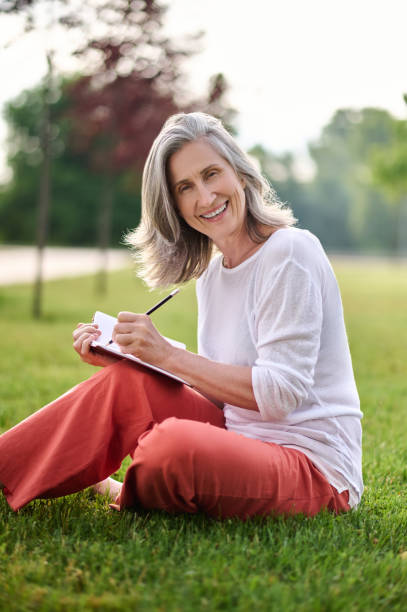 istock Smiling woman taking notes on lawn 1333500861