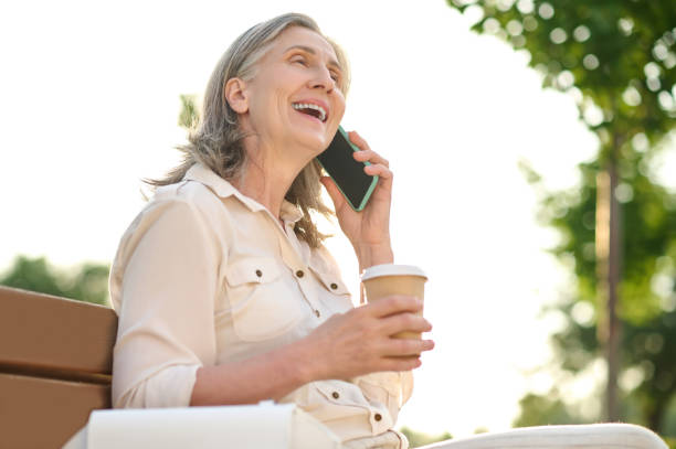 istock Joyful woman with coffee talking on smartphone 1333500938
