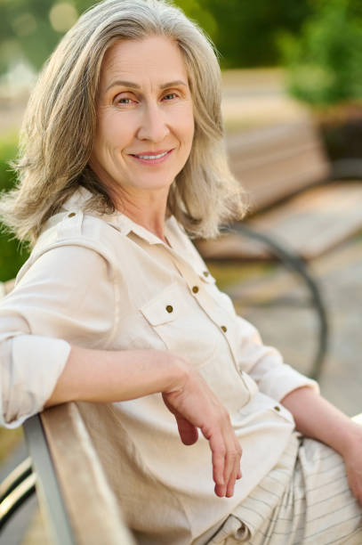 istock Confident adult woman smiling on bench 1333500962