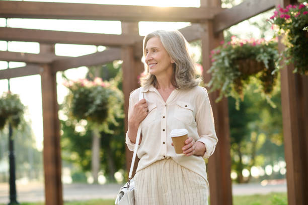 istock Smiling confident woman with handbag and coffee 1333500965