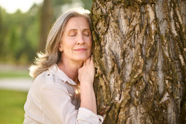 istock Woman with closed eyes leaning face against tree 1333500994
