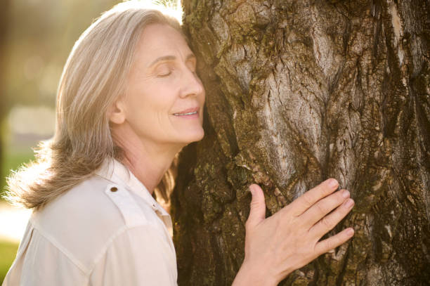 istock Adult smiling woman leaning against tree 1333500995