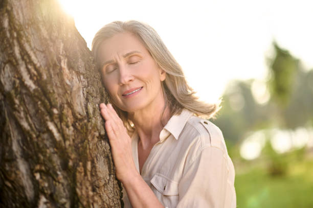 istock Woman with drooping eyelids leaning against tree 1333500996