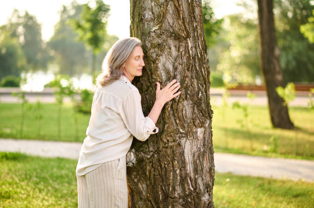 istock Calm woman near tree in park 1333500997