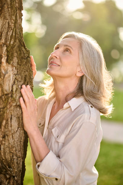 istock Woman touching tree with her palms looking up 1333500998