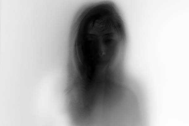 Woman face behind frosted glass stock photo