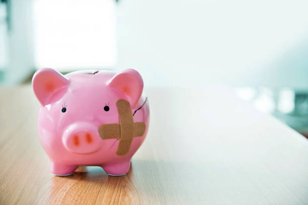 istock Broken piggy bank with adhesive bandage on the table 1333504641
