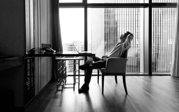 Businessman leaning on chair with hands behind head