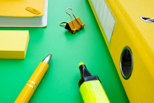 istock Yellow pen, folder and notepad on the green background. Paperwork and office supplies. 1333508497
