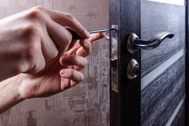 istock The carpenter with a screwdriver installs and adjusts the door lock 1333510546