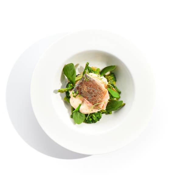 istock Panfried Fish with broccoli and green spinach. Healthy roasted cod with asparagus espuma. Fried Fish on white restaurant plate isolated on white background. 1333511592
