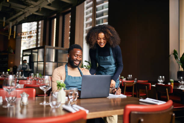 restaurant managers working with laptop - family business stockfoto's en -beelden