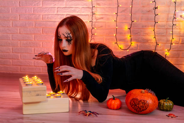 istock Halloween Witch near candles, garland on background. 1333513380