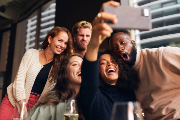 Friends pulling faces for selfie in bar