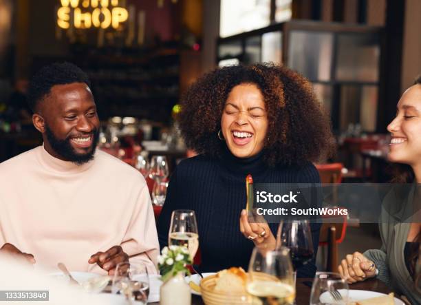 Woman eating meal and laughing in restaurant