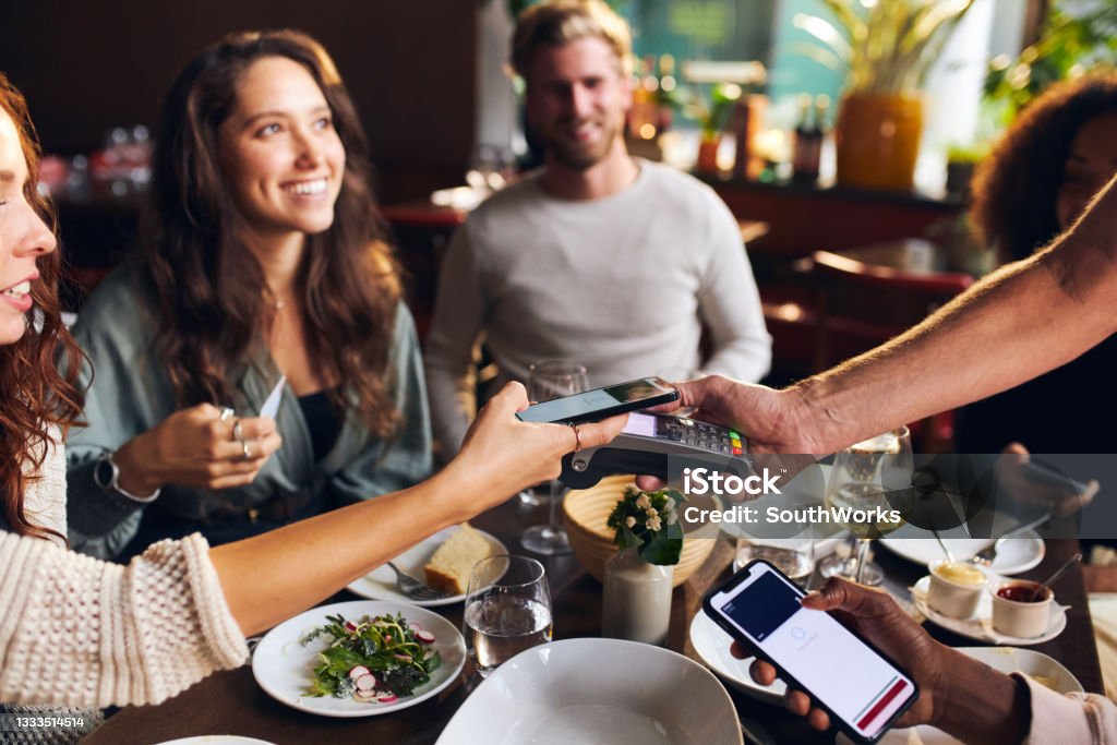 Amici che pagano senza contatto al ristorante - Foto stock royalty-free di Ristorante